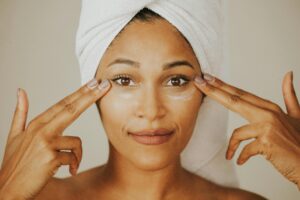 Woman cleansing her face gently with a soft towel.